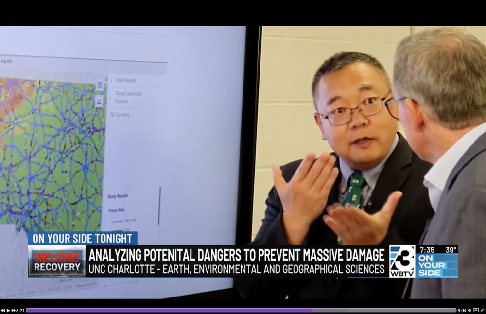 Wenwu Tang talks in front of a map of NC with their data model.